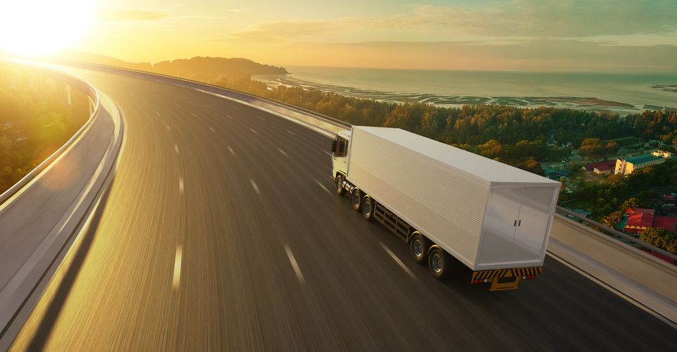 Delivery truck on the road at sunrise
